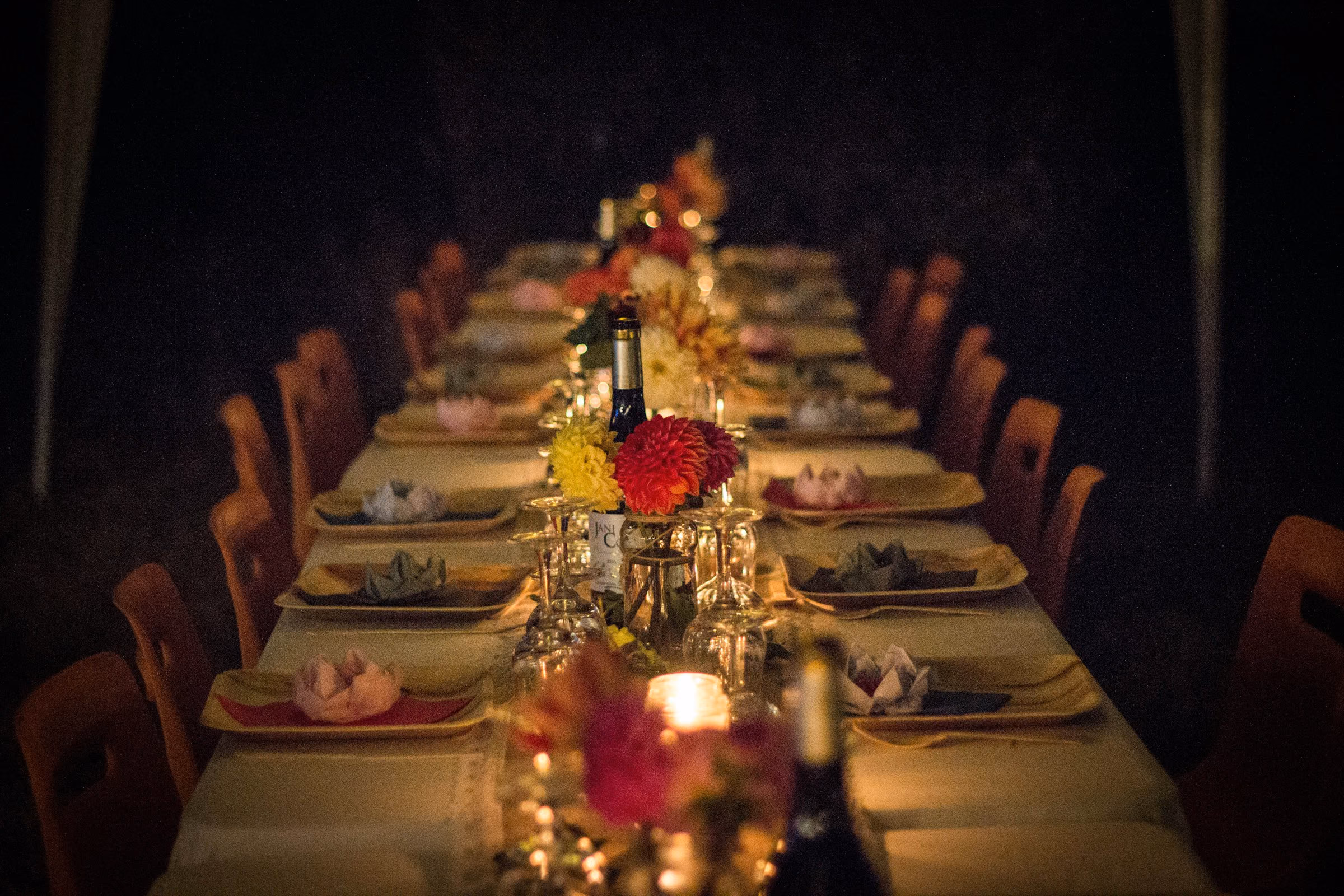 Long candlelit banquet table laid for dinner