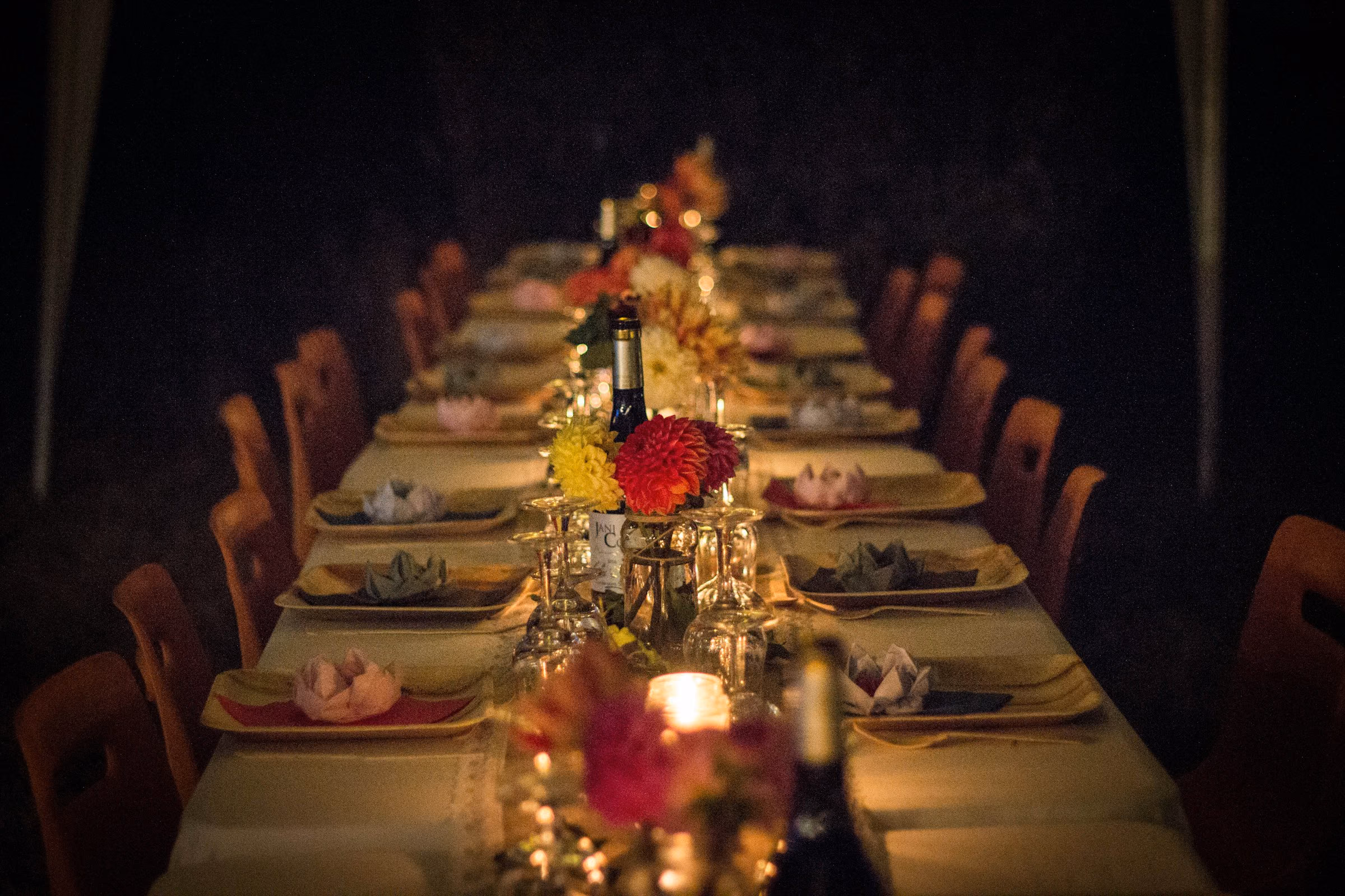 Long candlelit banquet table laid for dinner