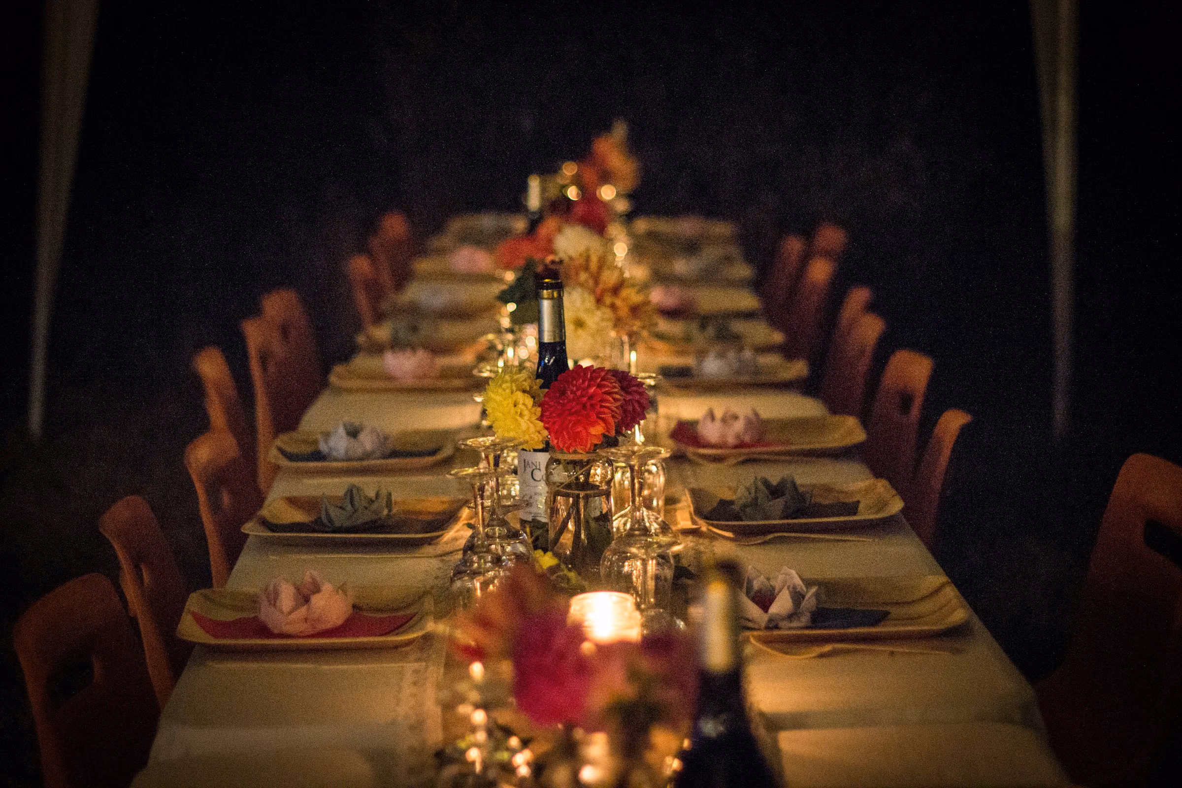 Long candlelit banquet table laid for dinner