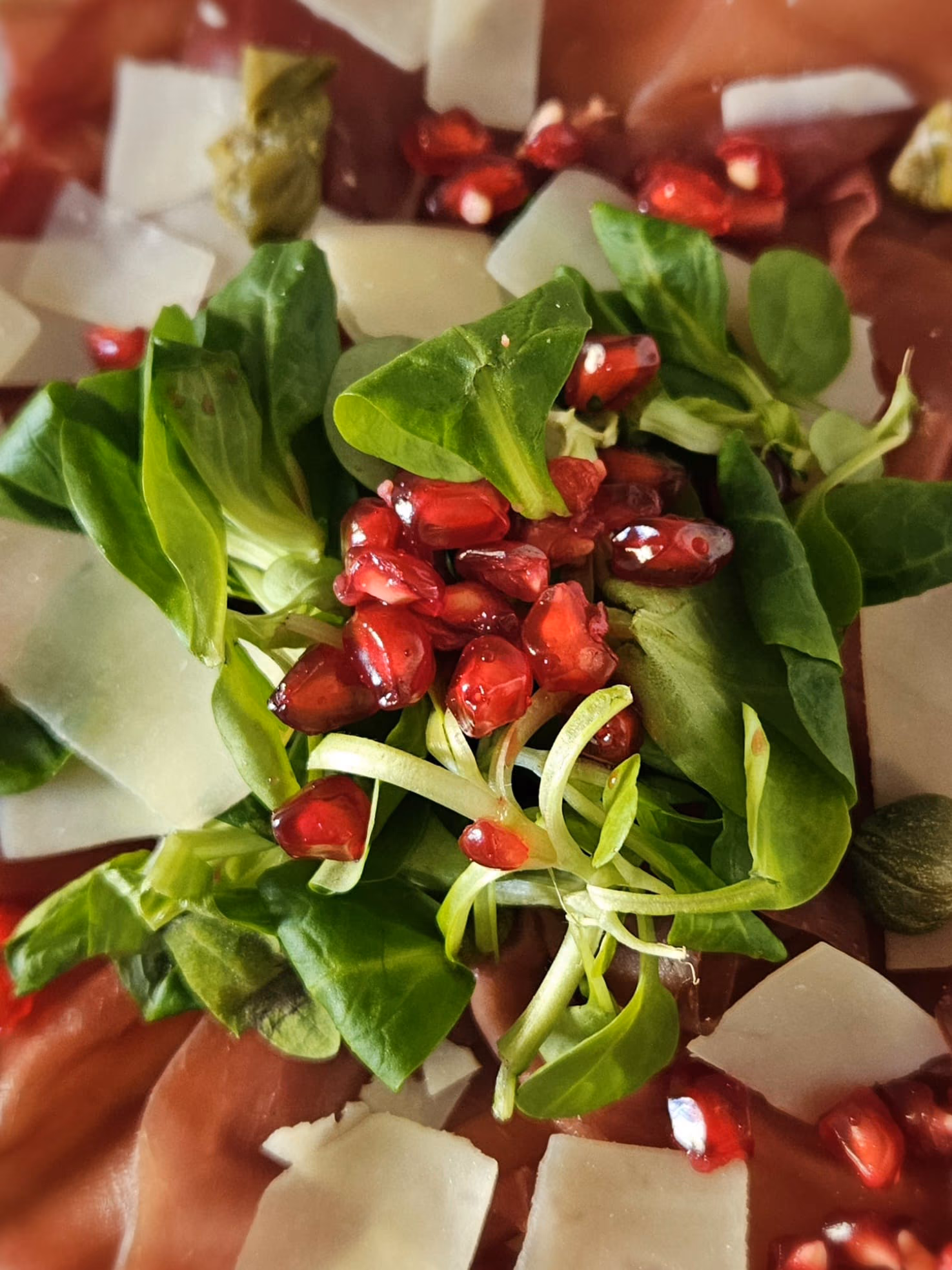 Bresaola with lamb’s lettuce, pomegranate seeds, parmesan and capers