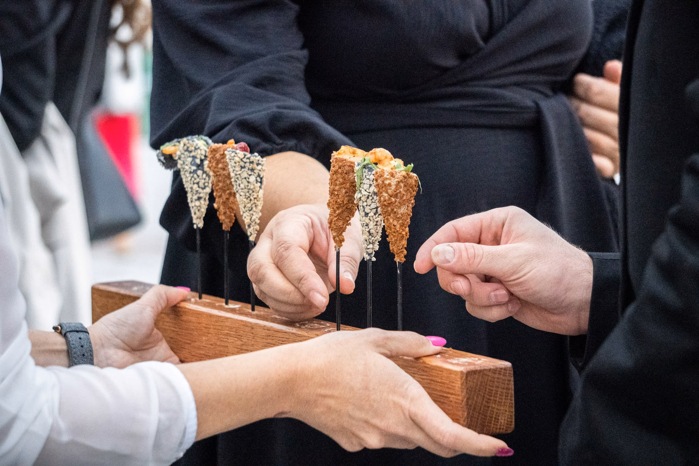Canapé cones offered to guests from a wooden stand