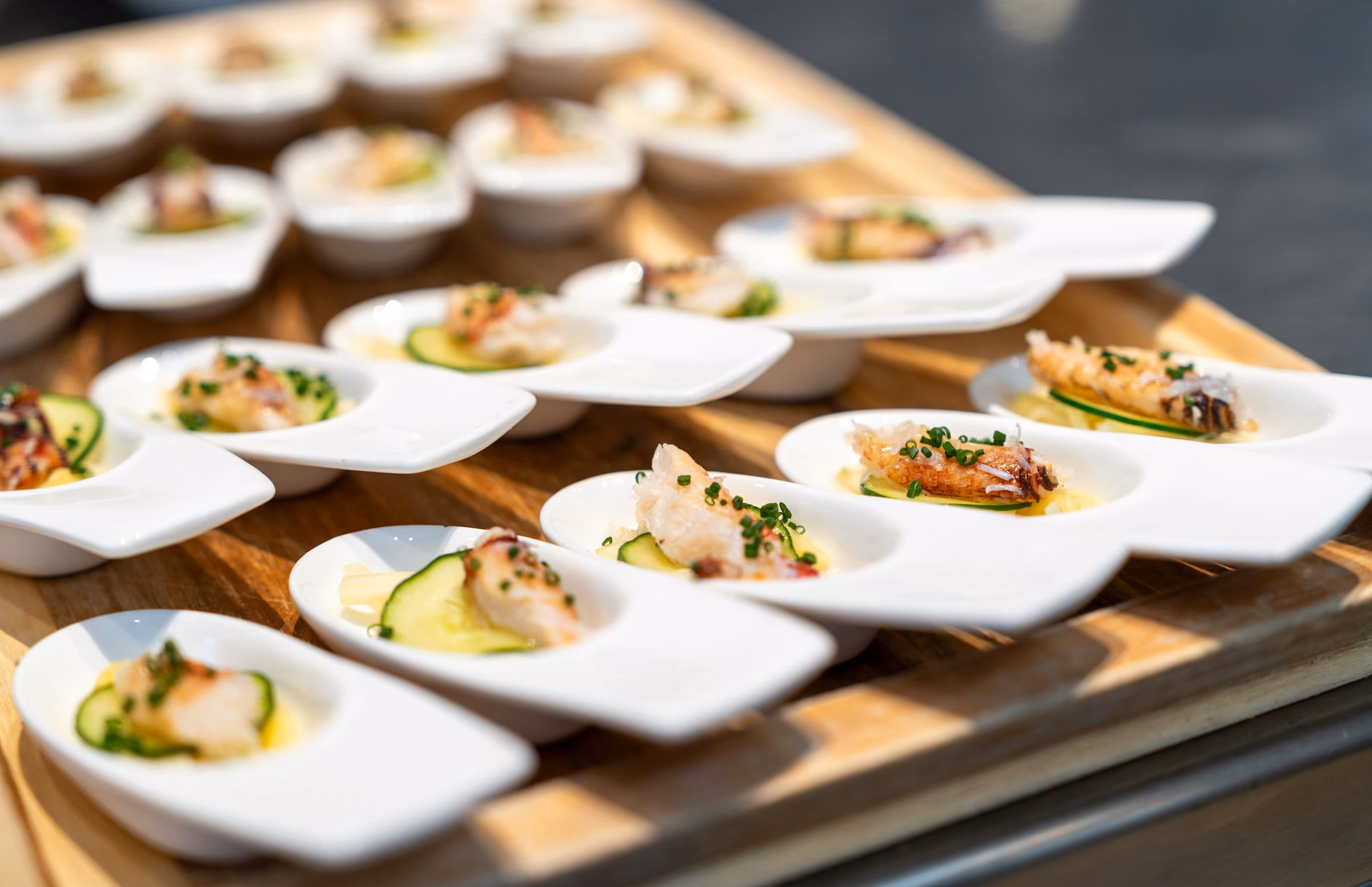 Tasting spoons of crudo lined up on a board