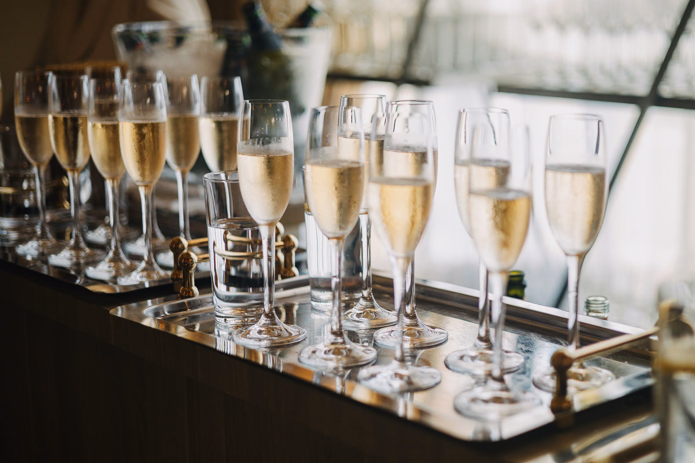 Silver tray of champagne flutes on the bar
