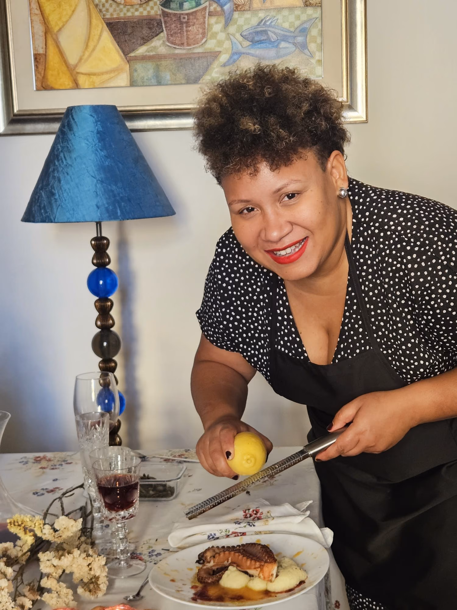 Hemi Castillo zesting a lemon over a plated dish at a dining table