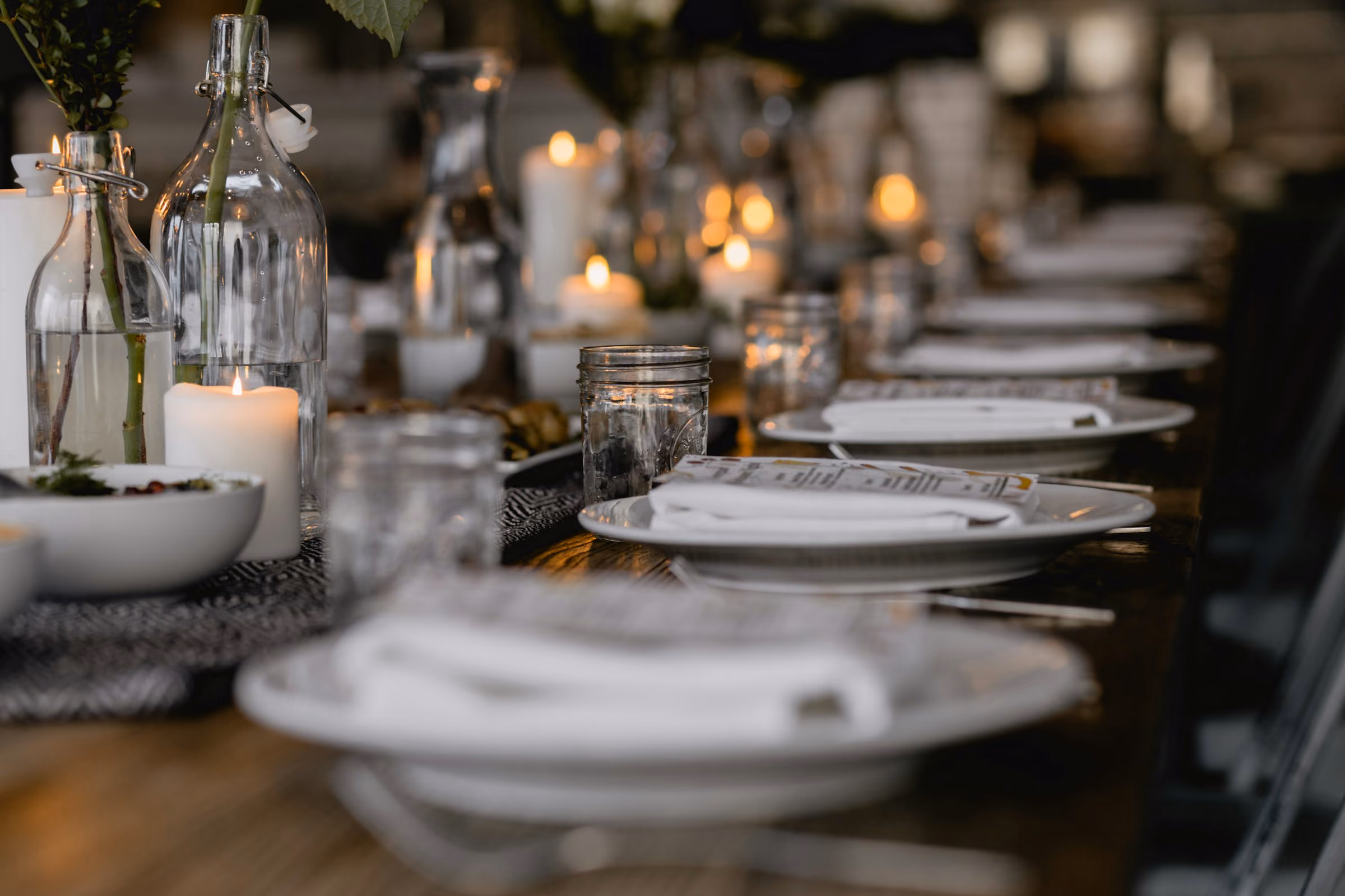 Long dinner table set with candles and linen