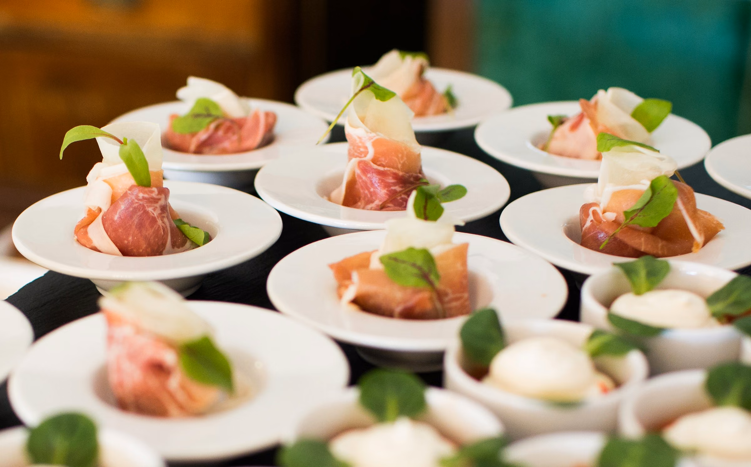 Plated starters of cured ham and burrata ready for service